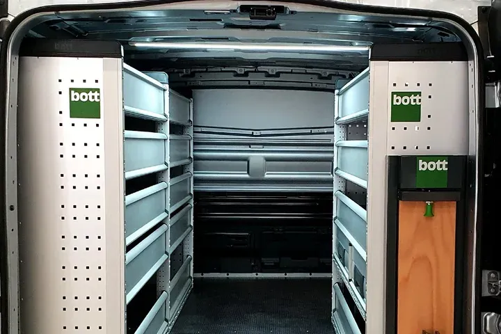 Fourgon aménagé de meubles aluminium Bott vu par les portes arrière ouvertes