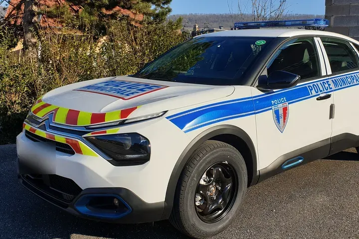Berline électrique de police municipale avec rampe lumineuse bleue et marquage réfléchissant
